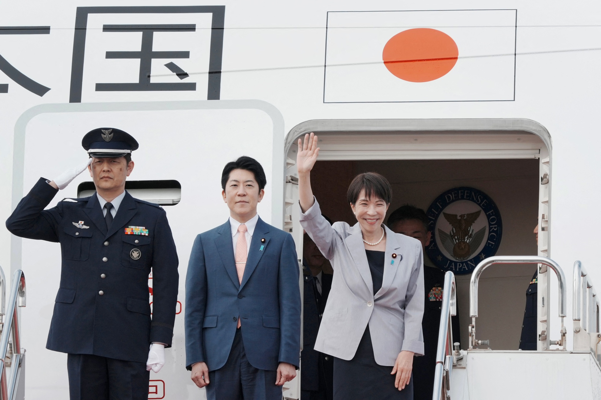 Sanae Takaichi, right, waves at Haneda airport as she departs for an official trip to Vietnam and Australia on May 1. Photographer: Kazuhiro Nogi/AFP/Getty Images