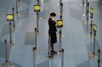 A Japan Airlines employee adjusts a social distancing sign at Haneda Airport in Tokyo.