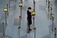 A Japan Airlines employee adjusts a social distancing sign at Haneda Airport in Tokyo.
