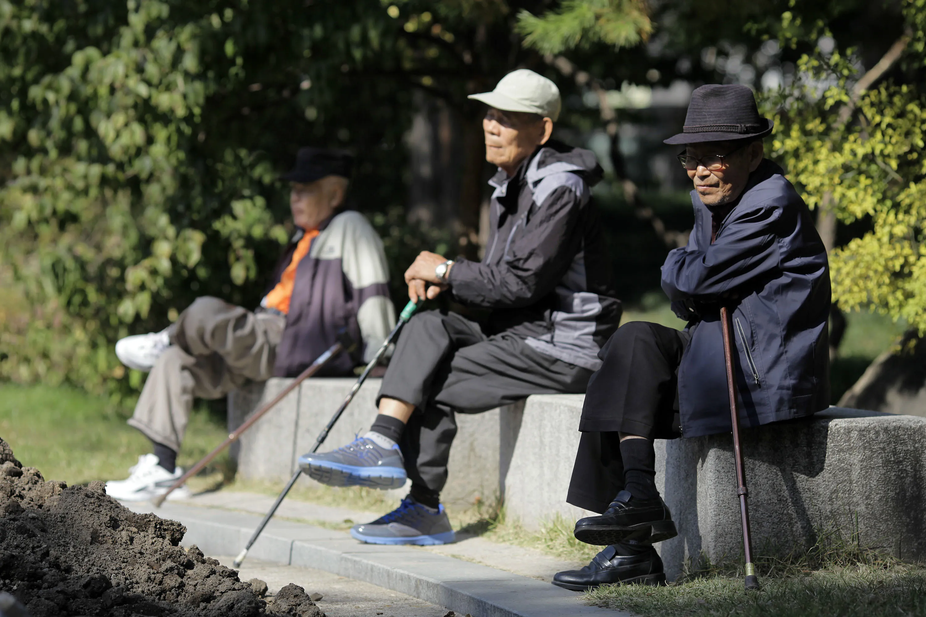 Elderly men sit on benches at Tapgol Park in Seoul, South Korea. Photographer: Woohae Cho/Bloomberg
