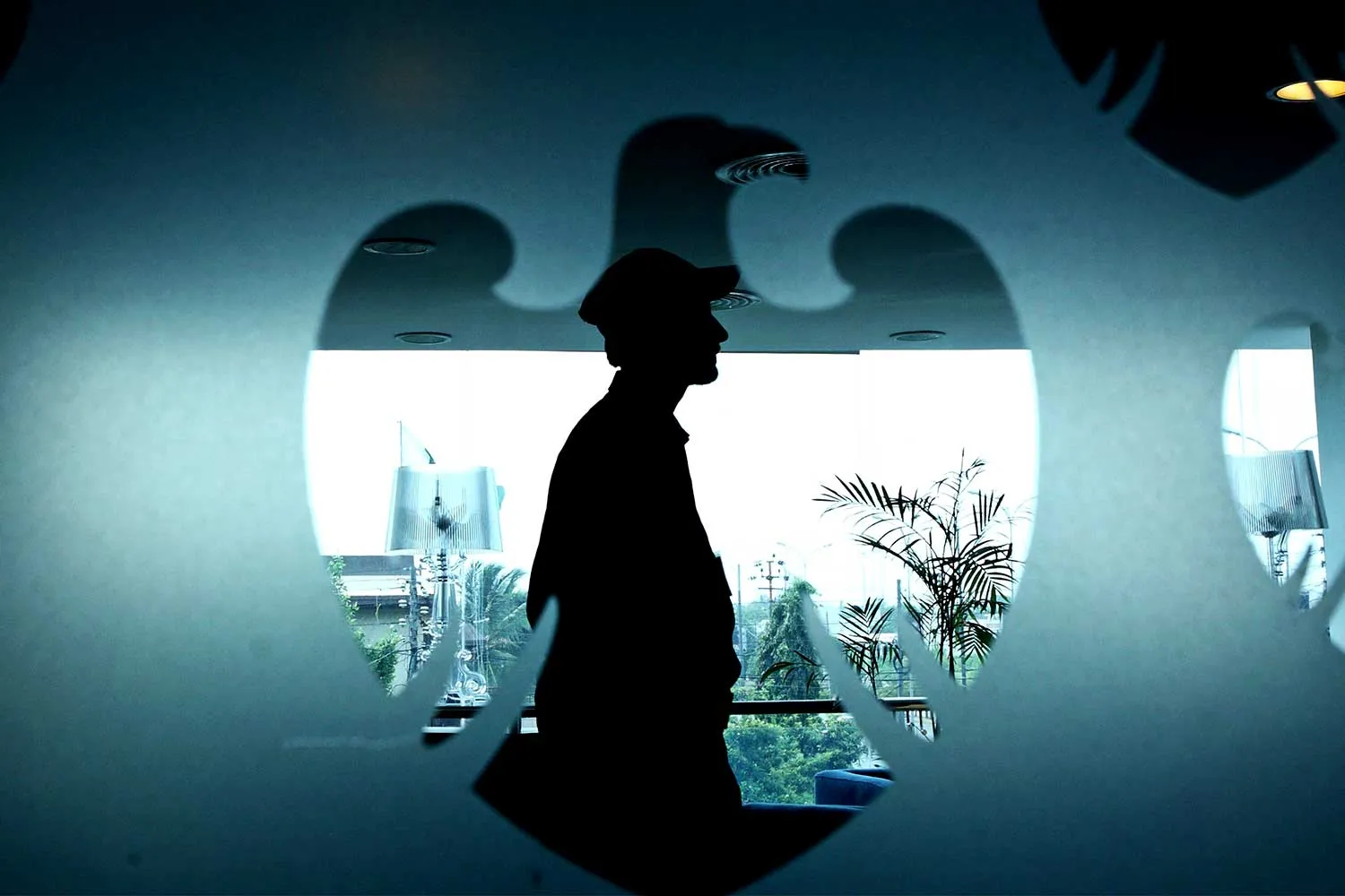 A security guard&nbsp;seen through the Barclays&nbsp;logo&nbsp;inside a bank branch.