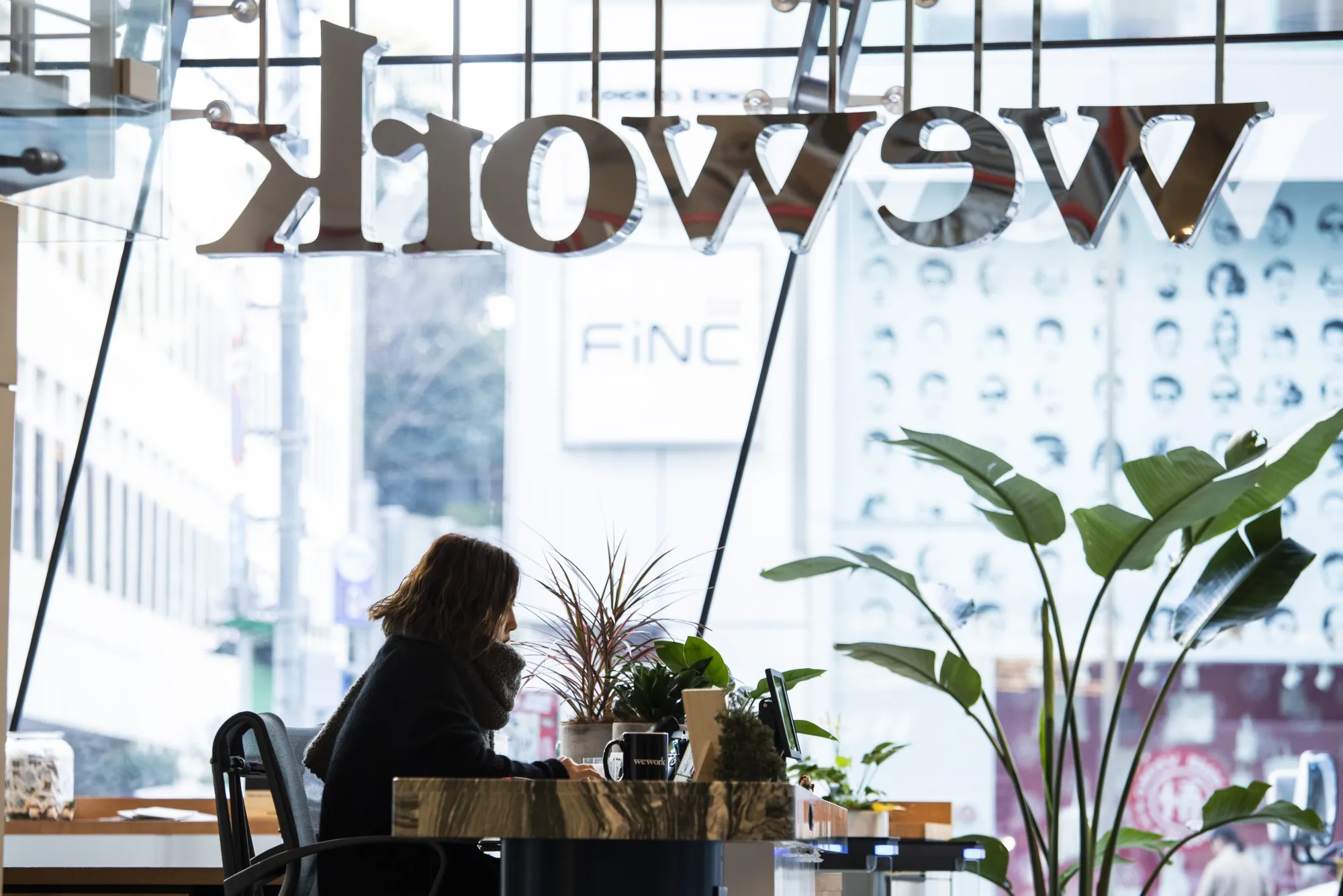A receptionist sits behind a counter at the WeWork Cos. Iceberg co-working space in Tokyo, Japan.