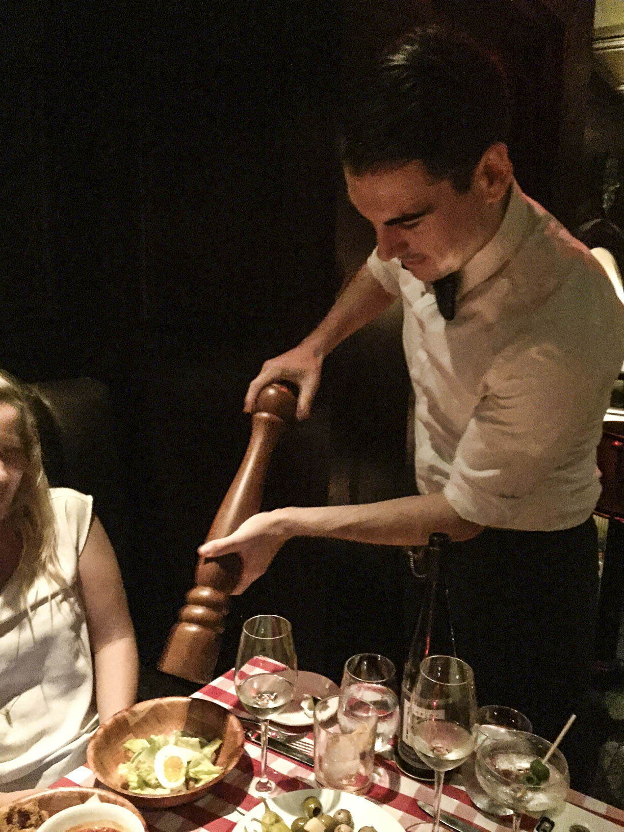 Waiter with a gargantuan pepper mill/grinder and a client with a