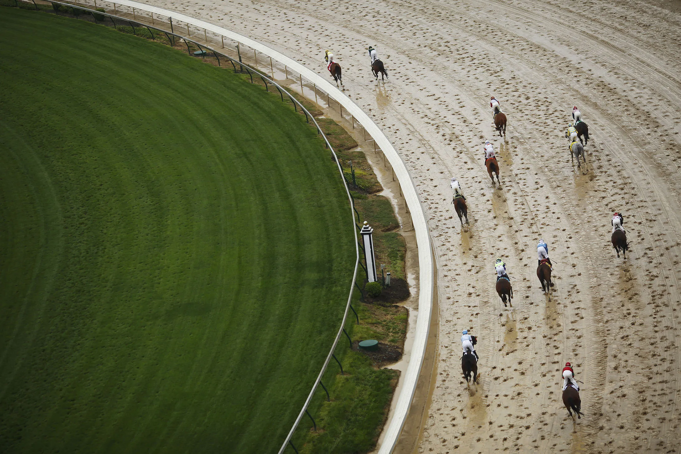 Thoroughbred racehorses round a turn after crossing the finish line during race on the eve of the Kentucky Derby at Churchill Downs in Louisville, Kentucky, U.S., on Friday, May 5, 2017. The 143rd running of the Kentucky Derby will feature a field of twenty horses with the winner receiving a gold trophy plus an estimated $1.24 million payday.
