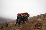 Cemetery workers carry the coffin of a person who died from the coronavirus at the Nueva Esperanza cemetery in Lima, Peru, on June 17.