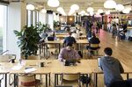 Members work on laptop computers in a common room at the Embarcadero WeWork Cos Inc. offices in San Francisco, California, U.S., on Thursday, Oct. 19, 2017. WeWork has focused its attention on Asia since 2016 with the opening of its first facility in Shanghai amid booming demand for flexible work spaces.