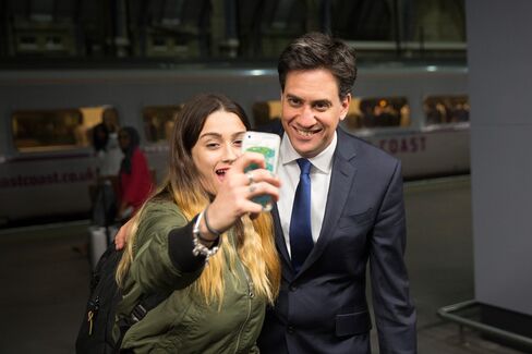 Labour Leader Ed Miliband poses for a 'selfie' photograph with a rail passenger in London on April 23, 2015.