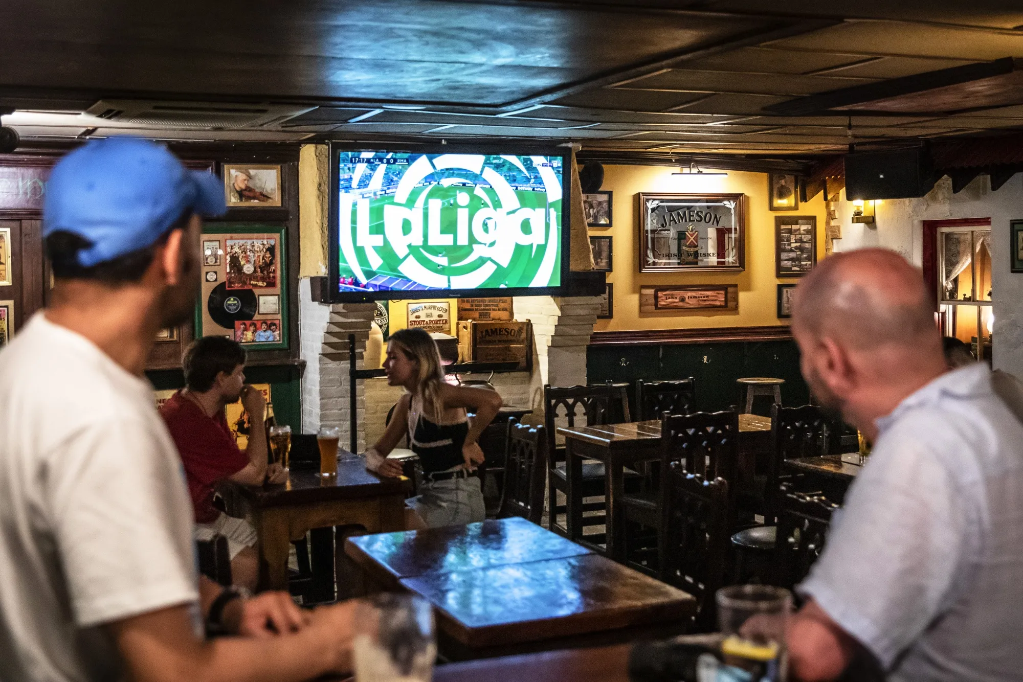 Soccer fans watch the La Liga match between FC Barcelona and Real Sociedad in a bar in Barcelona, Spain.