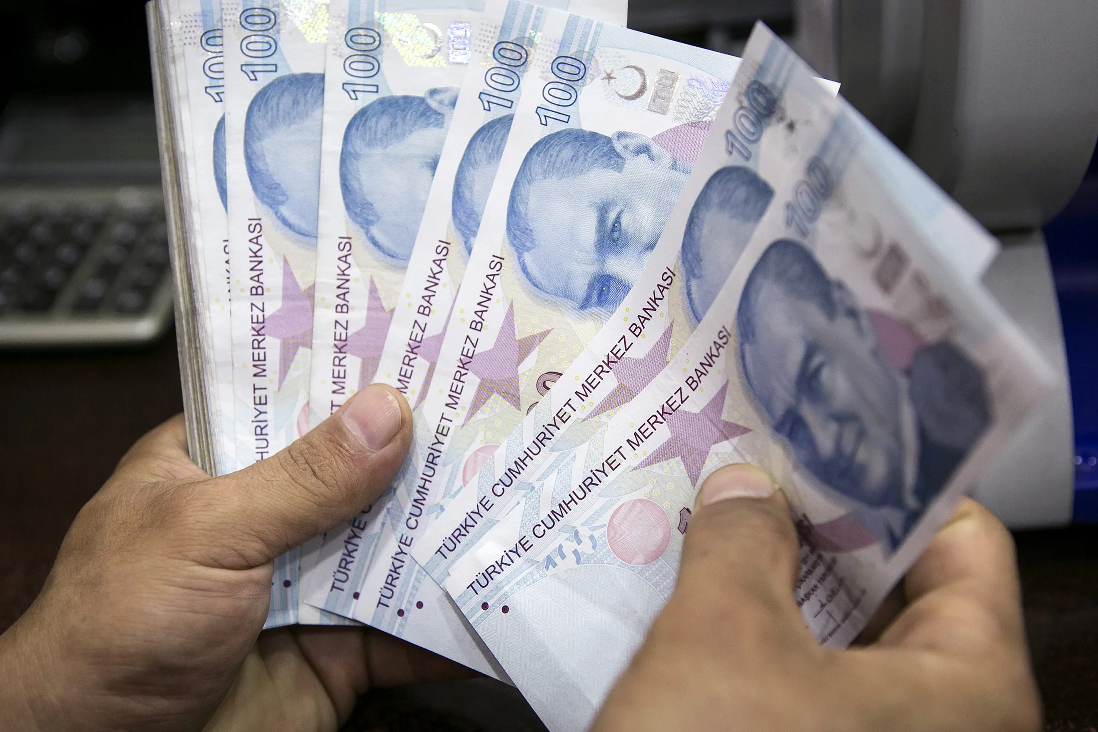 A cashier counts out 100 denomination Turkish lira banknotes at a currency exchange bureau in Istanbul, Turkey, on Thursday, Aug. 11, 2016. At least 10 lenders in the country announced they'd slashed interest charges on mortgage loans on Wednesday since President Recep Tayyip Erdogan said resistance to lower borrowing costs could be 'treason.'
