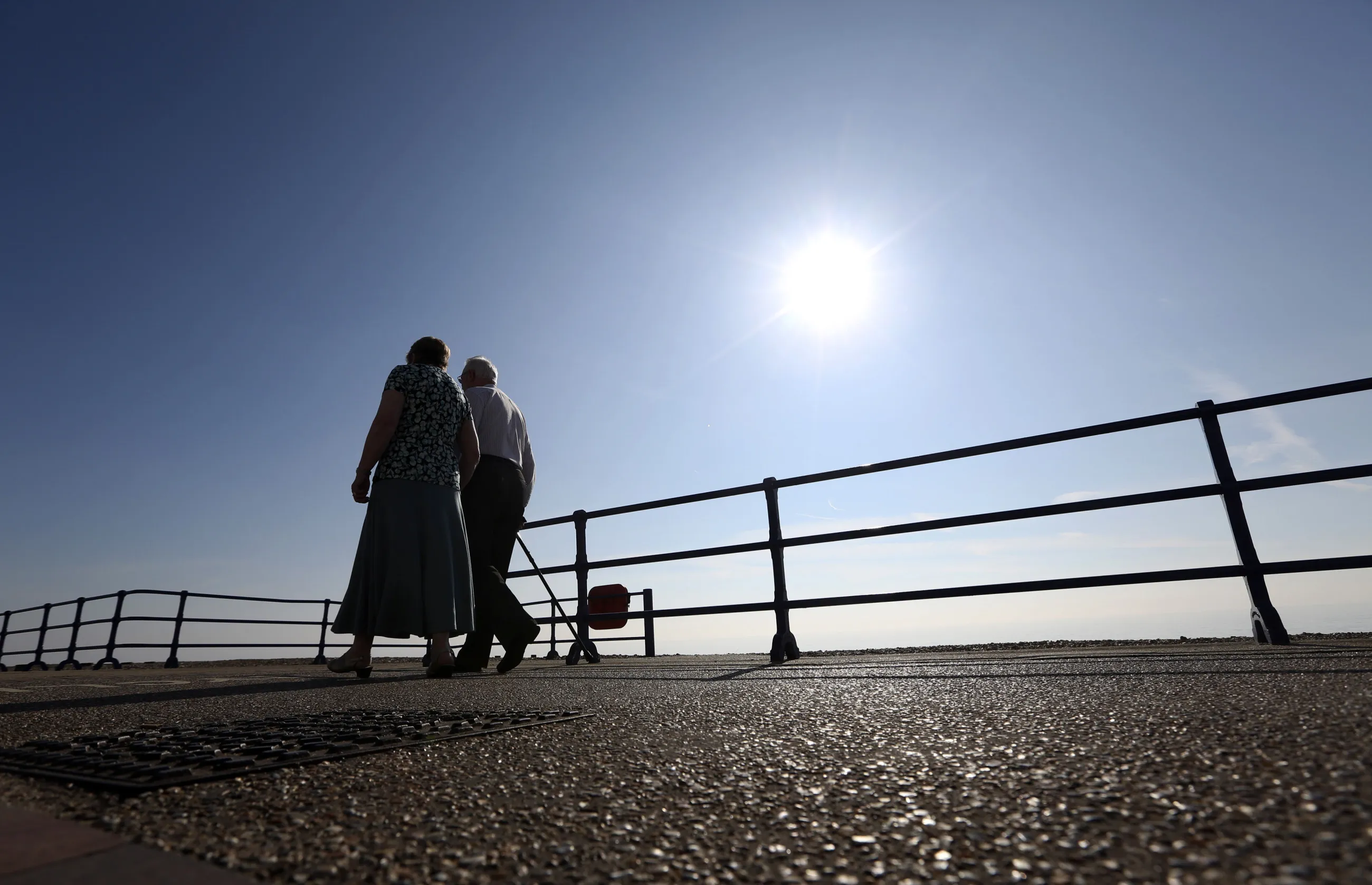 Pedestrians walk along the beachfront promenade in Eastbourne.