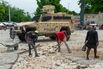 People clean the area following gang violence in Port-au-Prince, Haiti.