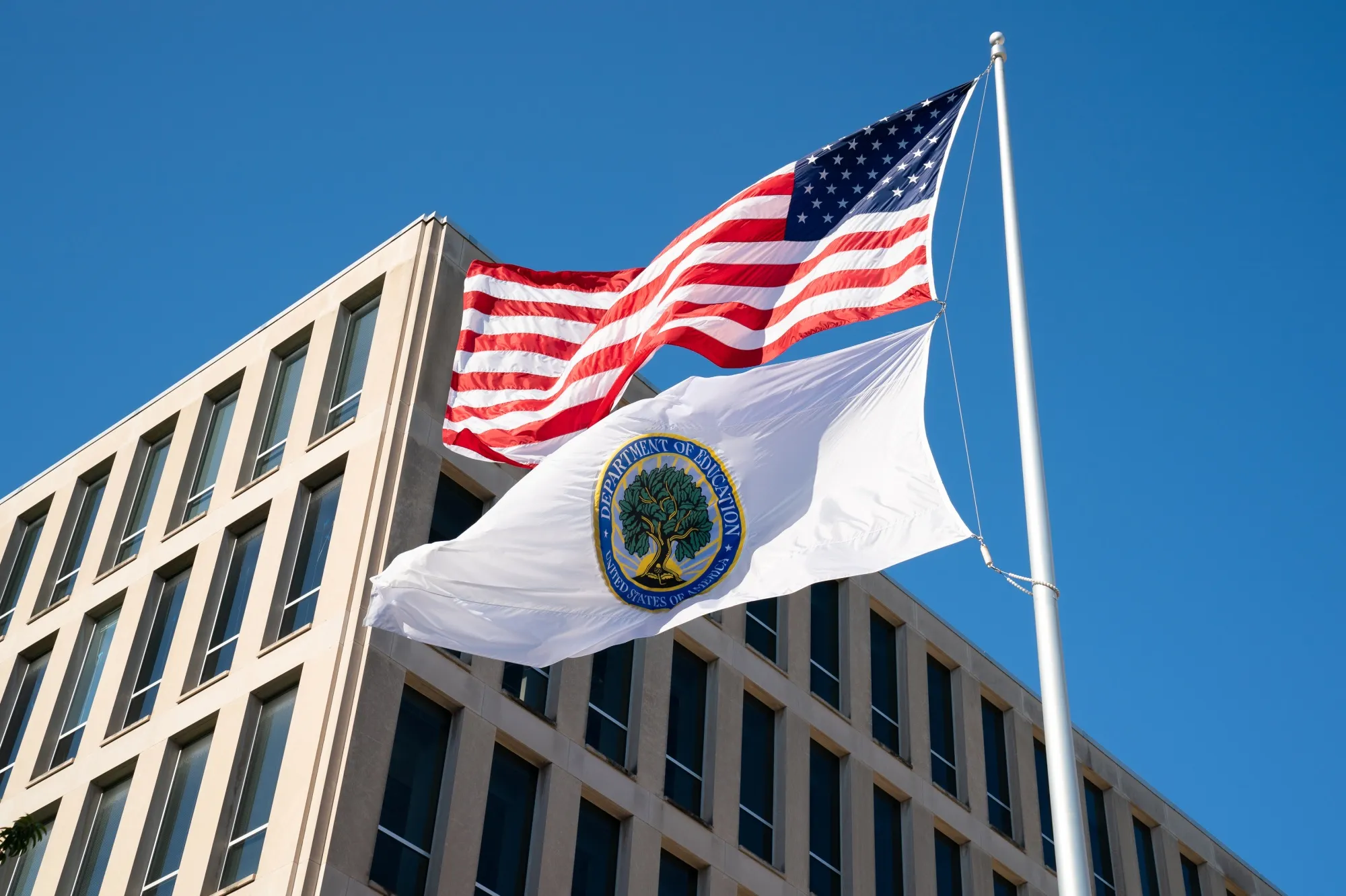 Flags for the US and the US Department of Education outside the Department of Education building in Washington, DC.
