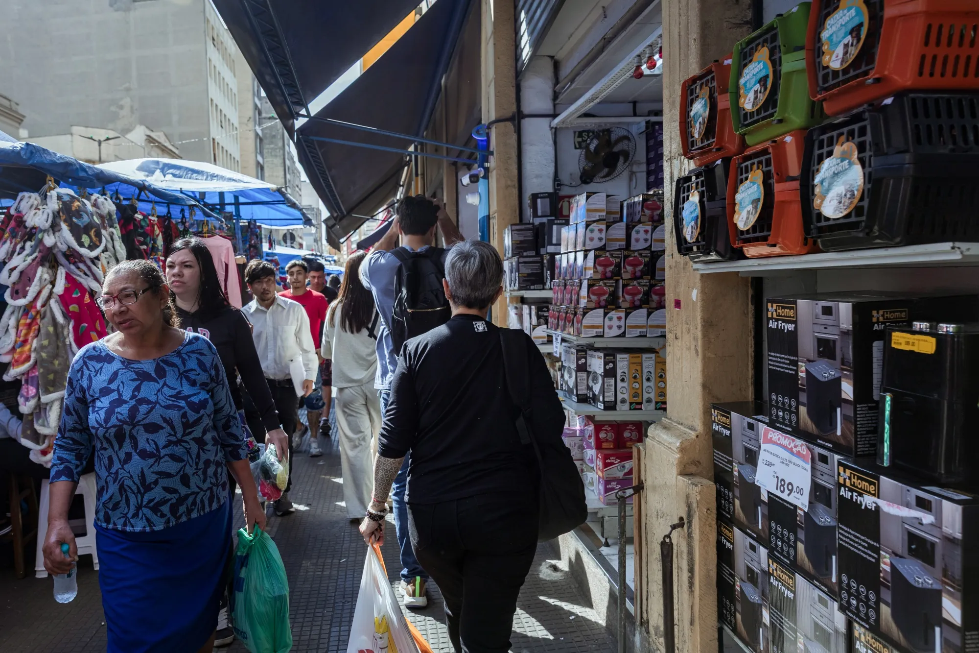 Shoppers pass retail stores in Sao Paulo.&nbsp;