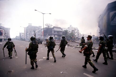 Indonesian armed forces patrol the streets during a riot in Jakarta on May 14, 1998.