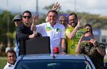 Jair Bolsonaro waves at supporters during a motorcade in Joinville, Santa Catarina State, on Oct. 1.