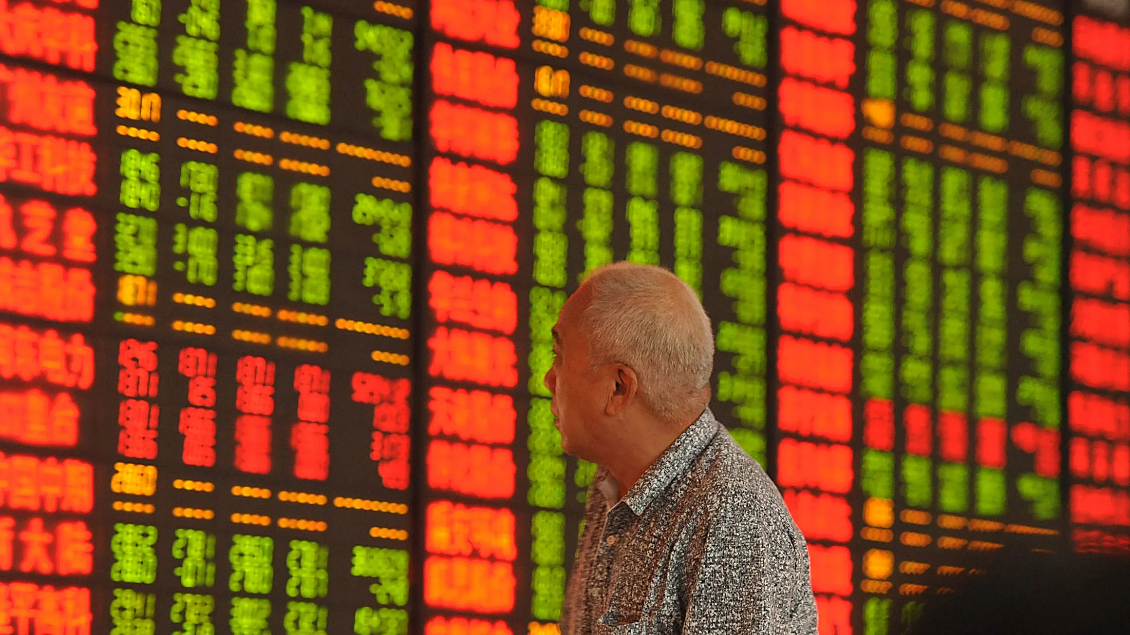 An investor watches the electronic board at a stock exchange hall on Aug. 18, 2015 in Fuyang, China.

