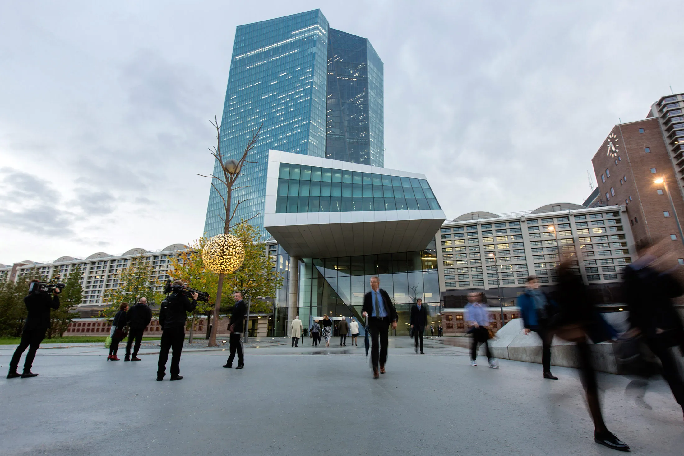 A television crew films outside the European Central Bank (ECB) headquarters stand in Frankfurt, Germany, on Tuesday, Oct. 6, 2014.
