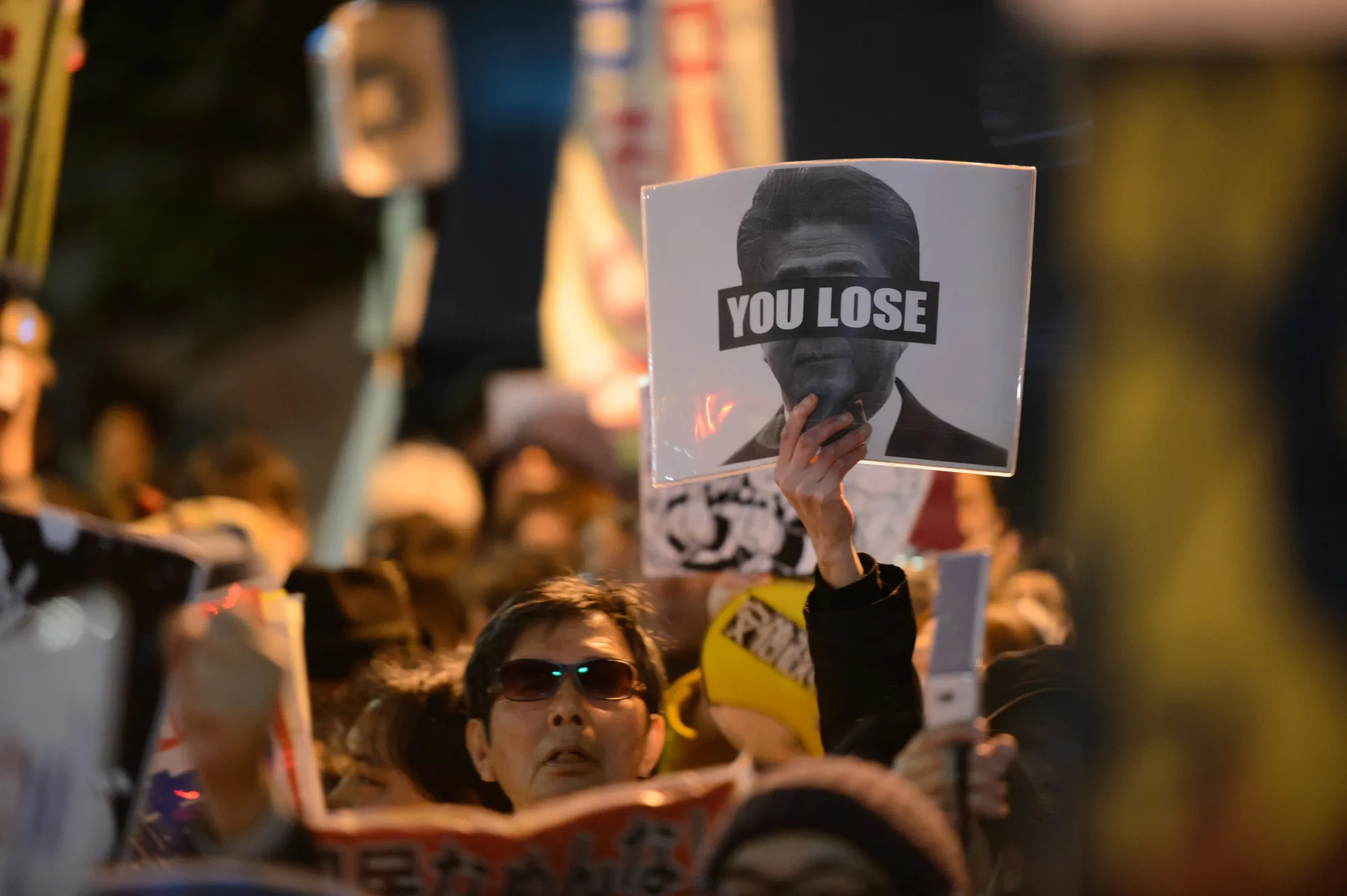 A demonstrator holds up a placard during a protest against Japan’s Prime Minister Shinzo Abe and Finance Minister Taro Aso&nbsp;in Tokyo on March 13.