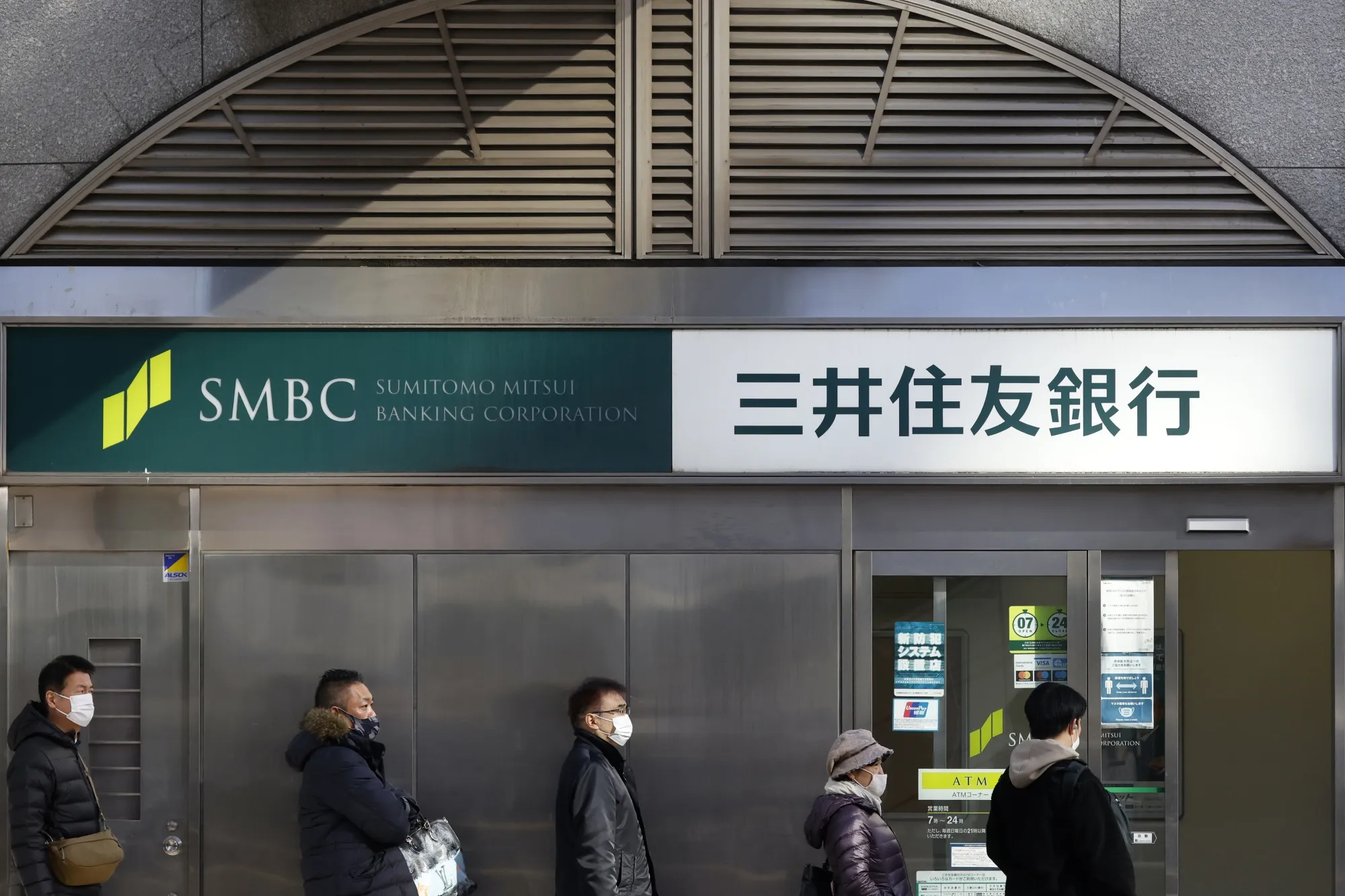 Customers queue in front of a branch of Sumitomo Mitsui Banking in Tokyo.