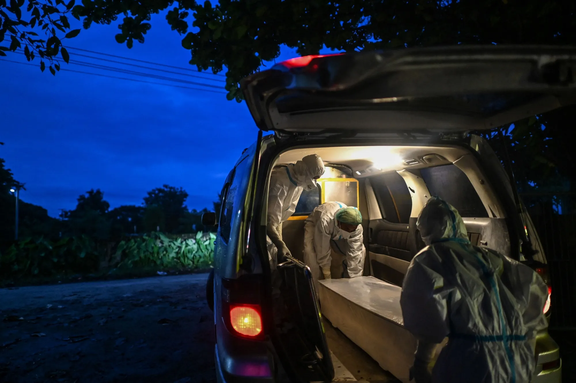 Volunteers load an empty coffin before picking up the body of a suspected Covid-19 victim in Myanmar’s Bago region on Aug. 6.