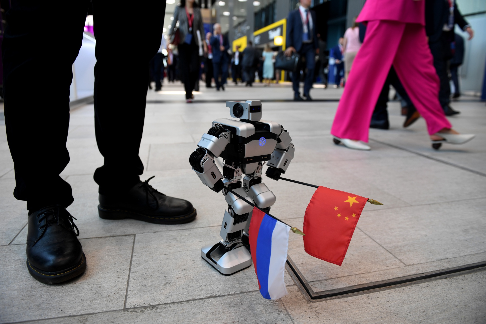 A mini-robot carries the flags of Russia and China in the main hall during the St. Petersburg International Economic Forum in Russia in 2019.&nbsp;