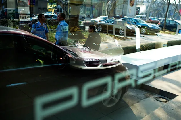 Two security guards stand outside a Porsche dealership in Hangzhou, China