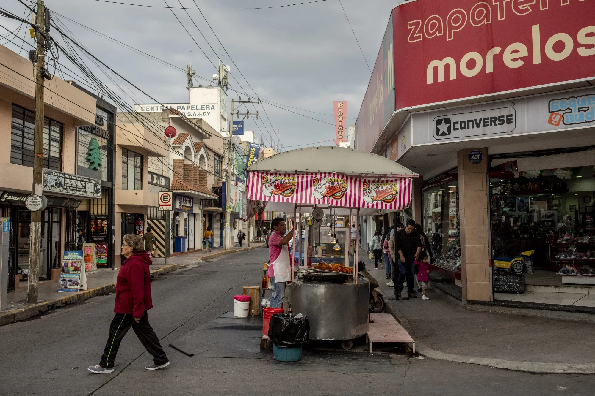 Pedestrians pass in front of a food vendor&nbsp;in Tulancingo, Hidalgo state, Mexico.