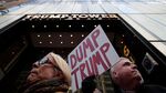 David Schleicher (right) holds up a sign during a protest against Donald Trump outside of Trump Tower on Oct. 26, 2016, in New York City.