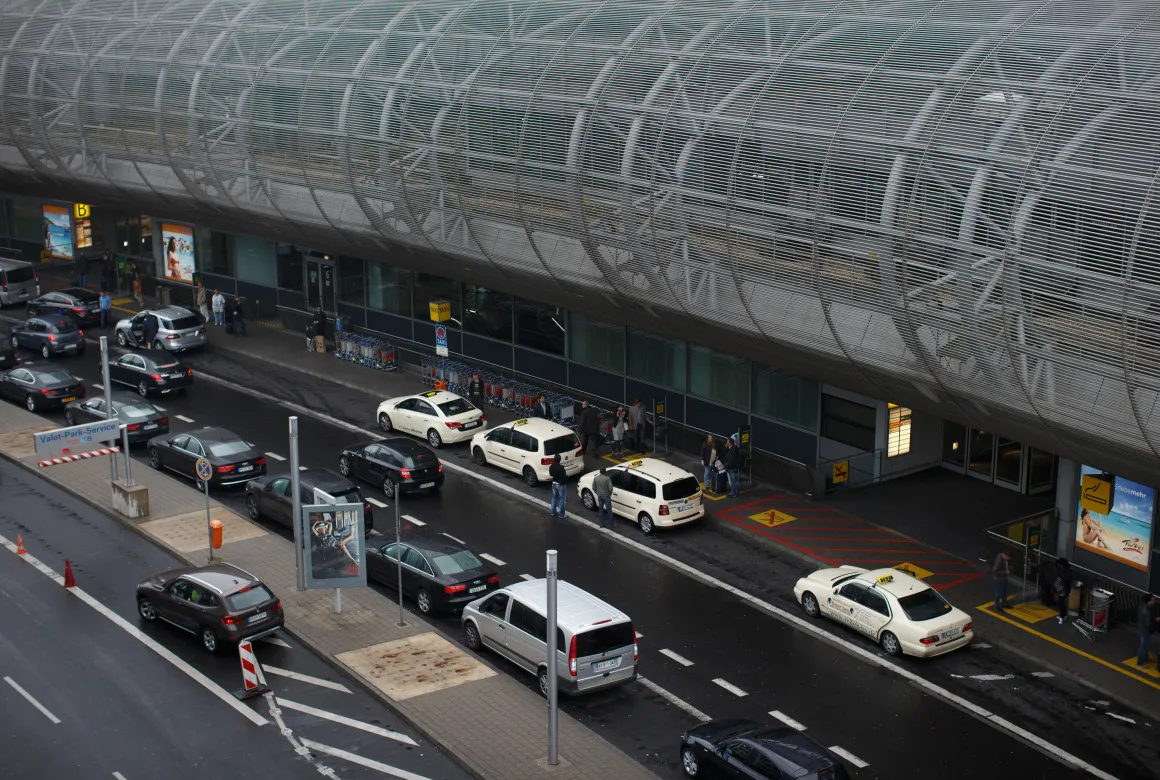 Automobiles and taxis stand outside Dusseldorf airport.
