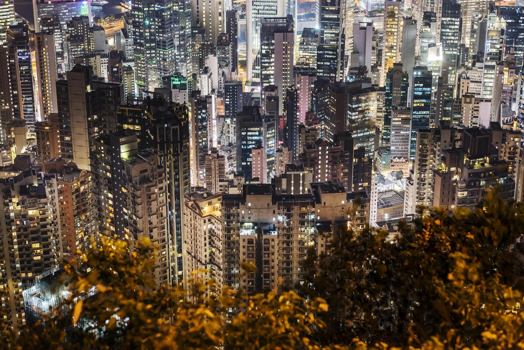 Residential and commercial buildings stand illuminated at night in Hong Kong, China on Friday, Nov. 27, 2015. Secondary private residential property prices dropped 3.9 percent since peaking in September, according to an index published by broker Centaline Property Agency Ltd.
