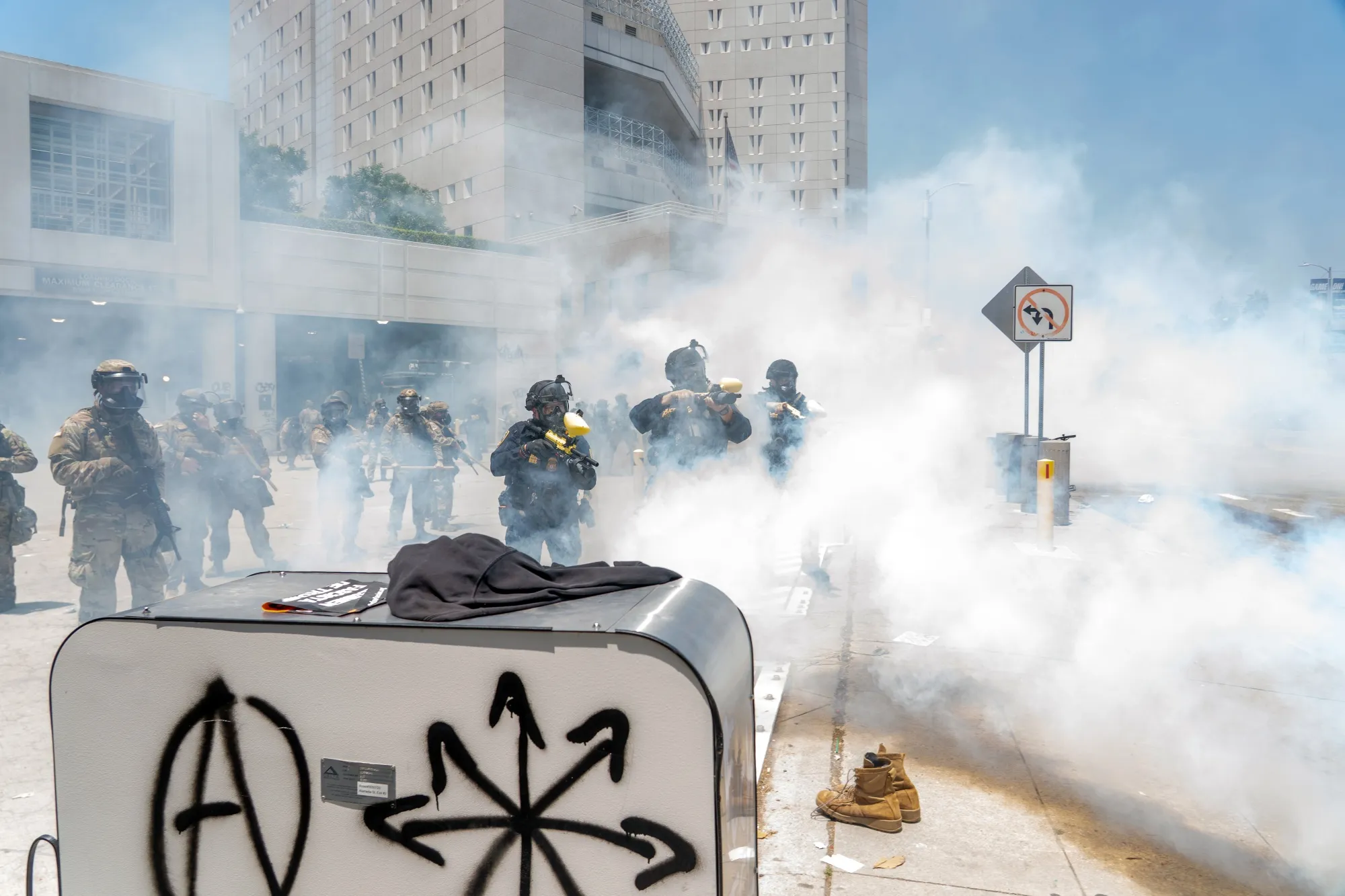 National Guard soldiers and law enforcement officers use tear gas to deter protesters Sunday at the Edward R. Roybal Federal Building in Los Angeles.