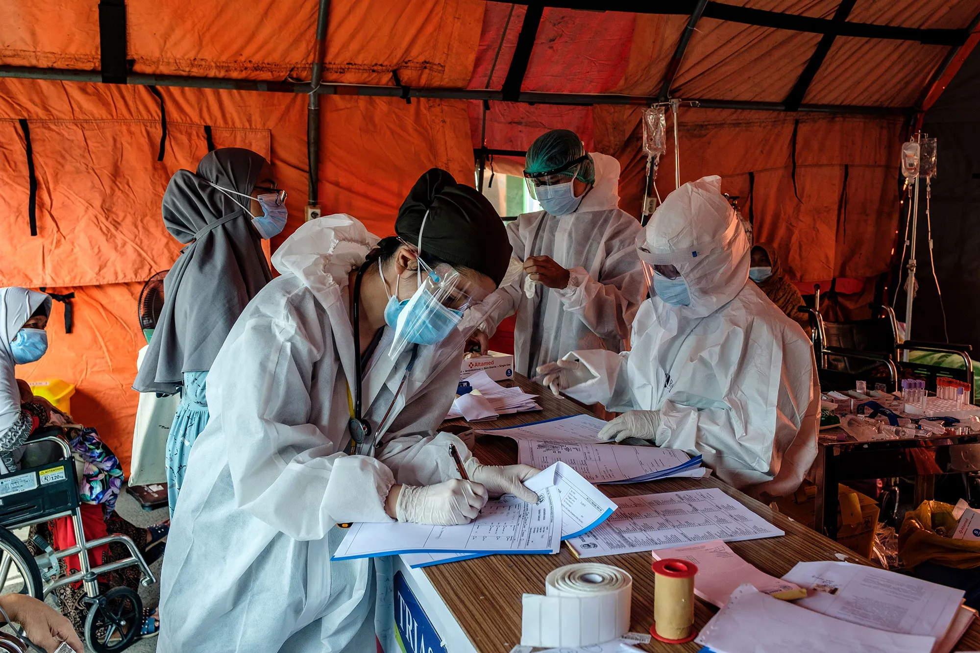 Nurses handle the paperwork for incoming patients in a tent set up to handle an overflow of Covid-19 patients at a hospital near Jakarta, on June 24.