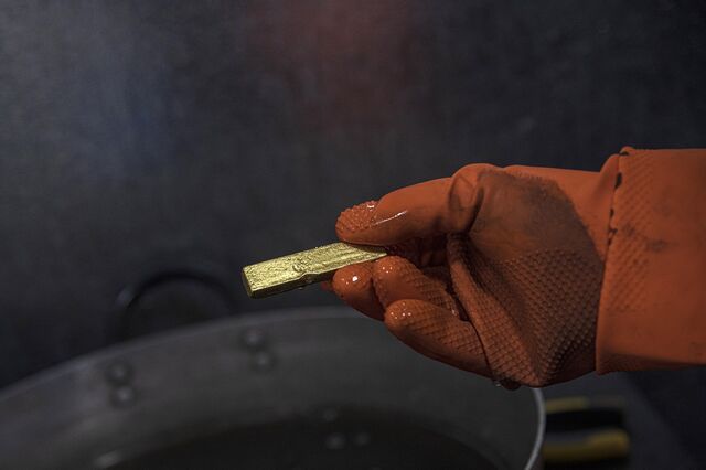 A worker holds a small processed gold ingot at a gold smelter refinery in La Paz,