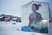 People pass a mural depicting a woman and a polar bear, in Nuuk, Greenland, on Jan. 21.
