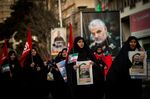 Mourners carry images of Iranian General Qassem Soleimani during a funeral ceremony in Tehran, on Jan. 6.