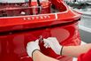 A worker fits a prancing horse badge to a vehicle on the production line at Ferrari's E-building factory in Maranello, Italy.
