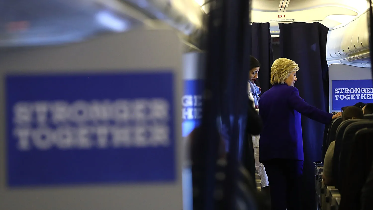 Democratic presidential nominee Hillary Clinton talks with members of her staff aboard her campaign plane while traveling from Orlando to New York on Sept. 21, 2016.
