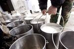 A dairy farmer moves buckets of raw milk at a Nestle SA milk collection center in Shuangcheng, Heilongjiang Province, China, on Jan. 11, 2012