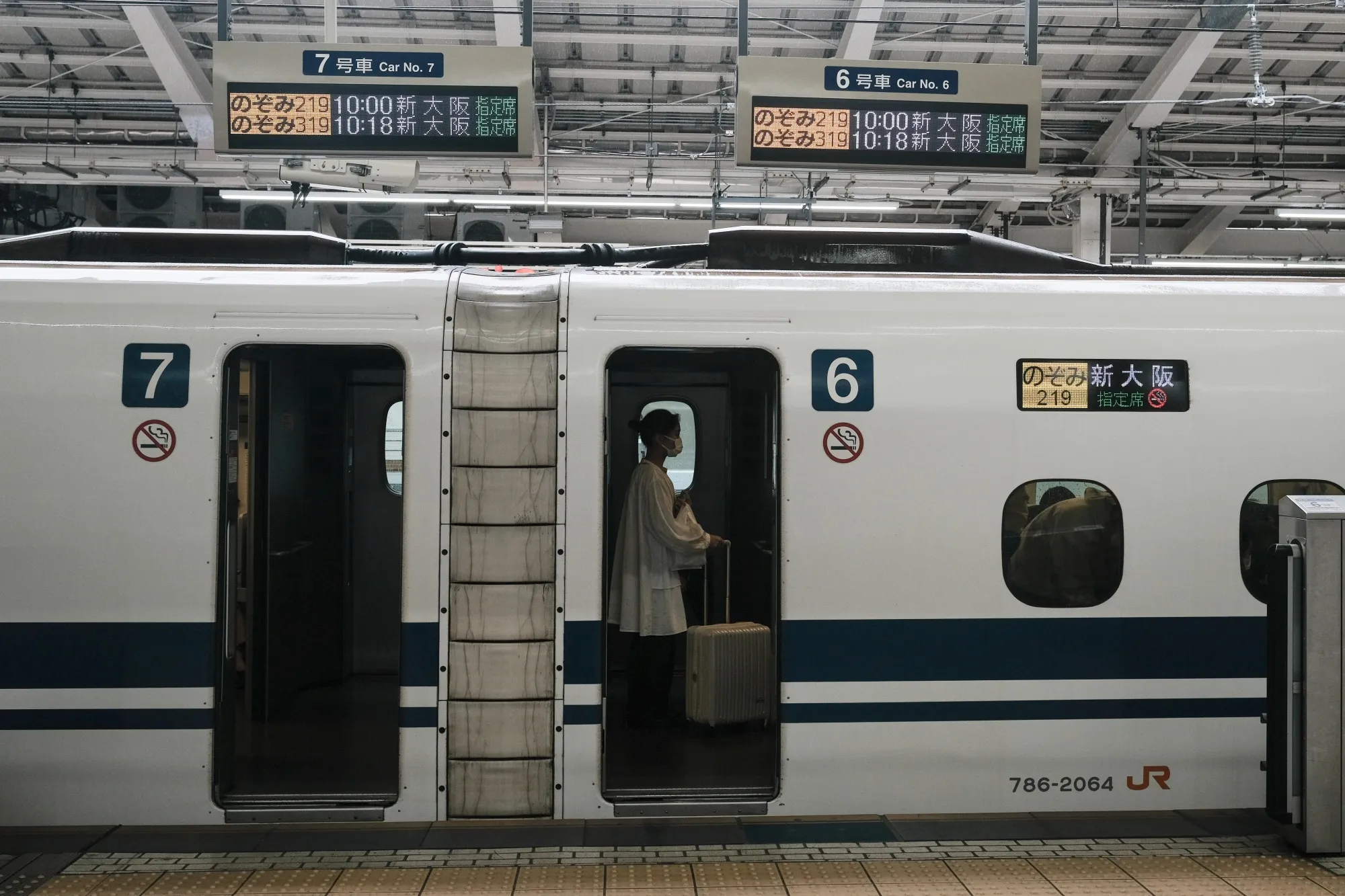 A passenger onboard an East Japan Railway Co. (JR East) Shinkansen bullet train on a platform at the Tokyo Station.