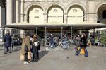 Pedestrians pass a restaurant in Milan.