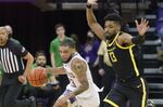 Washington guard Terrell Brown Jr., left, drives around Oregon forward Quincy Guerrier during the second half of an NCAA college basketball game Thursday, March 3, 2022, in Seattle. Washington won 78-67. (AP Photo/Ted S. Warren)