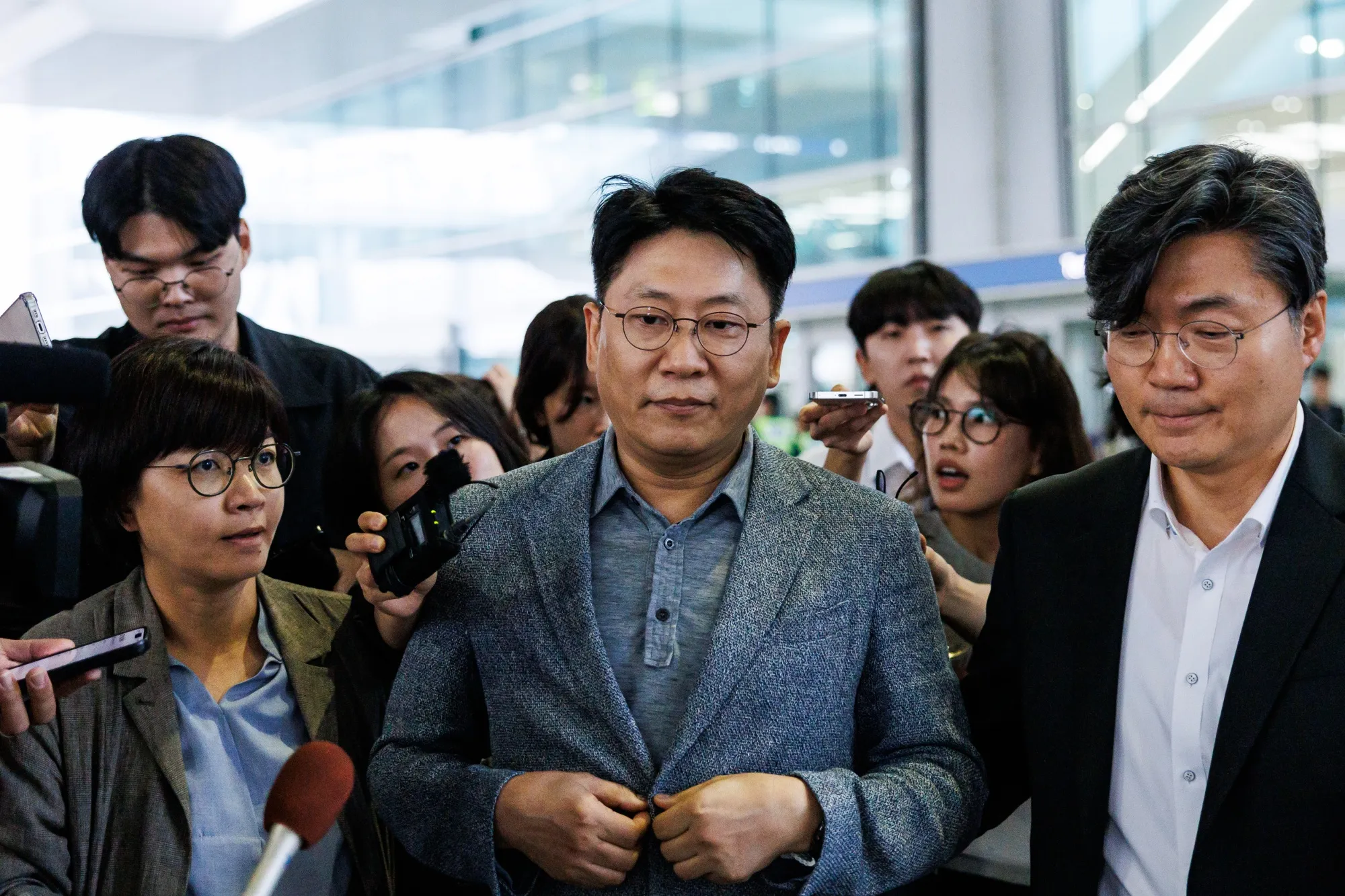 Kim Dong-Myung, chief executive officer of LG Energy Solution Ltd., center, is surrounded by members of media as he leaves the Incheon International Airport on Friday, Sept. 12, 2025. Hundreds of South Korean workers detained in the US sweep earlier this month have returned home on a chartered plane, ending a weeklong ordeal in an episode that has raised doubts about Korean investment and strained ties between the two allies.