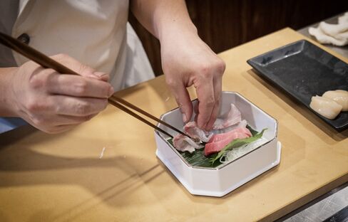 A sushi chef prepares a sashimi plate in Singapore