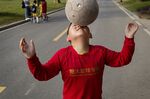 A young Chinese student balances a soccer ball on his nose near Qingyuan, in Guangdong Province, China.

