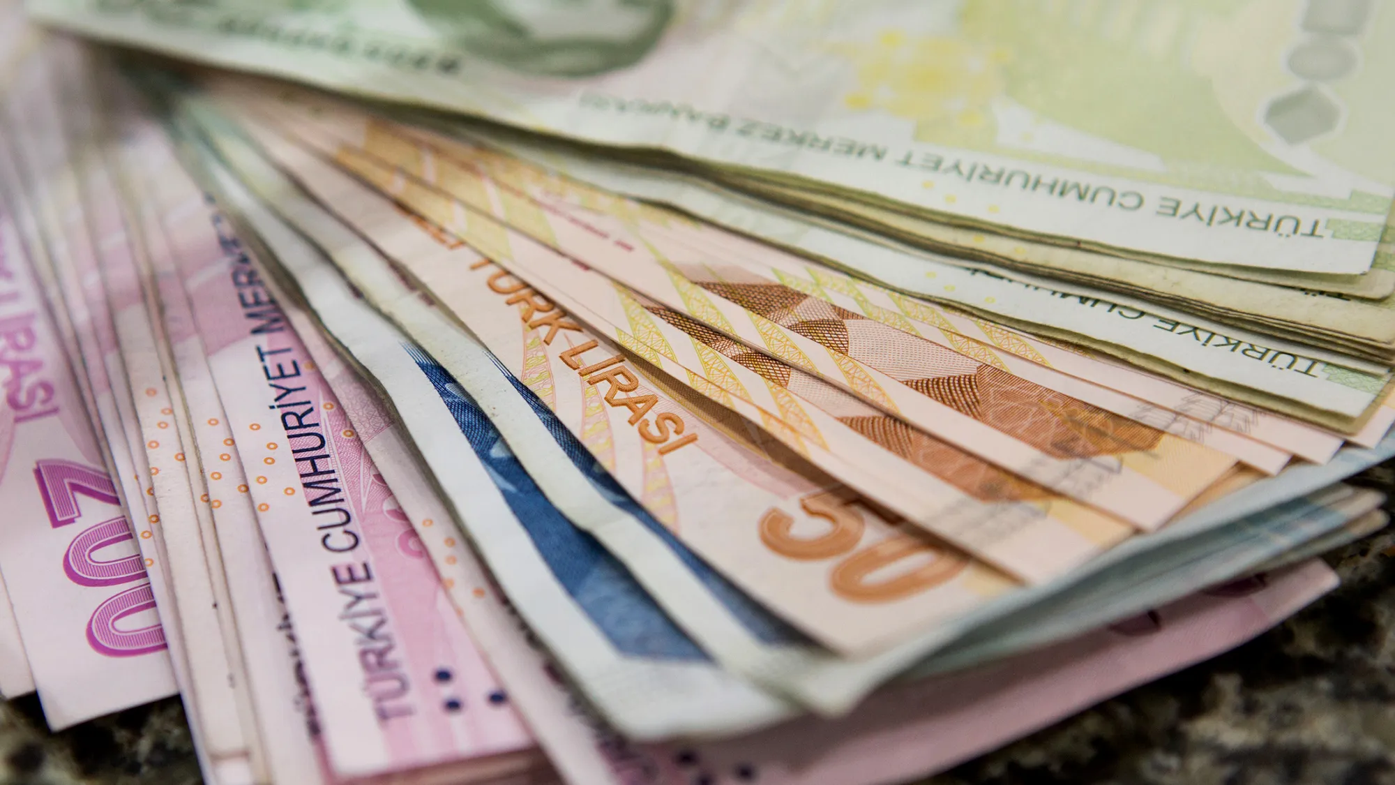 Turkish lira banknotes sits on the counter of a foreign currency exchange office in Istanbul, Turkey, on Friday, Oct. 30, 2015. As Turks prepare to vote this weekend, some analysts see an increasing likelihood the five-month political deadlock that roiled markets is nearing an end.
