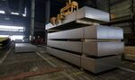 A worker watches as large aluminum slabs are moved by overhead crane in the foundry at the Krasnoyarsk aluminum smelter, operated by United Co. Rusal, in Krasnoyarsk, Russia.