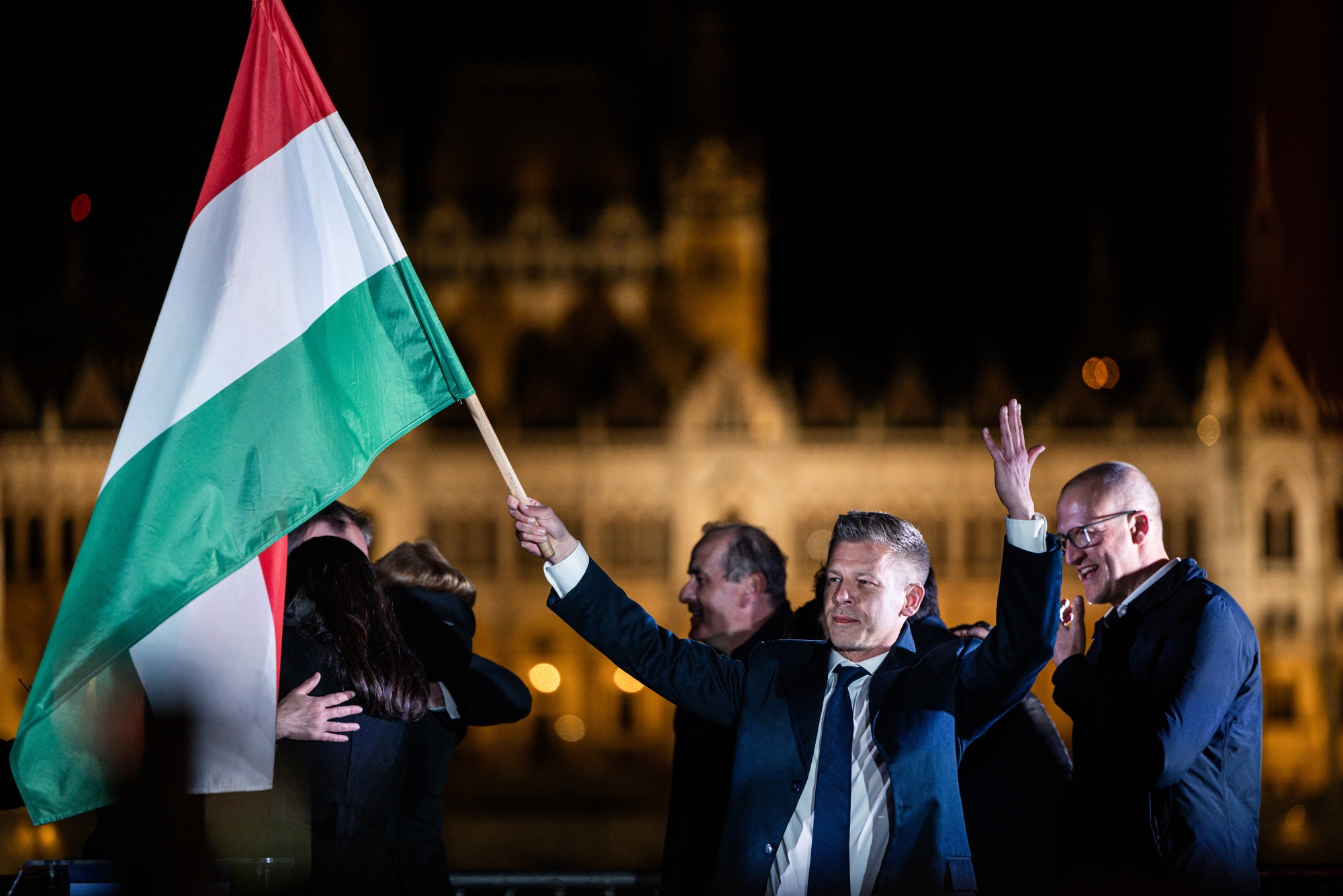 Peter Magyar, leader of the Tisza party, holds a Hungarian flag during an election night event during parliamentary elections in Budapest, Hungary, on Sunday, April 12, 2026. Peter Magyar, Hungary’s next prime minister, outlined sweeping changes after ending Viktor Orban’s 16-year rule in a landslide election victory that will redefine the country’s ties with the European Union, Russia and the US administration of President Donald Trump. Photographer: Akos Stiller/Bloomberg