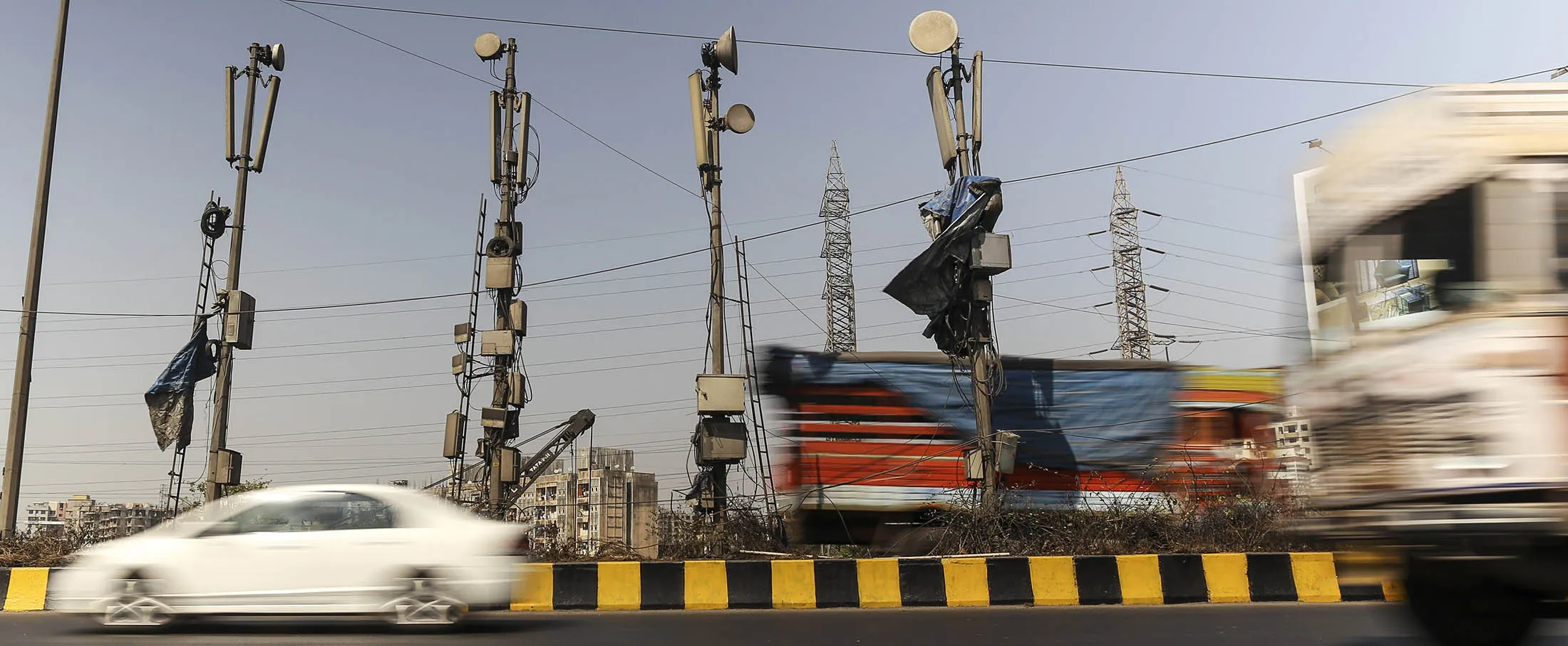 Vehicles drive past mobile-phone telecommunications towers in Mumbai, India, on Wednesday, Jan 29, 2014. Dhiraj Singh/Bloomberg
