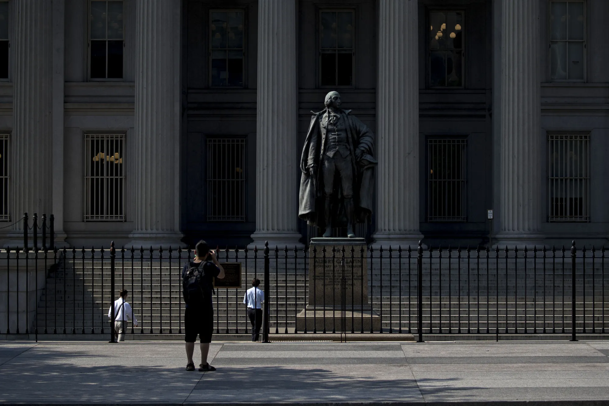 A visitor takes a photo&nbsp;of the&nbsp;statue of Albert Gallatin, former U.S. Treasury secretary,&nbsp;the outside the&nbsp;Treasury building in Washington, D.C.