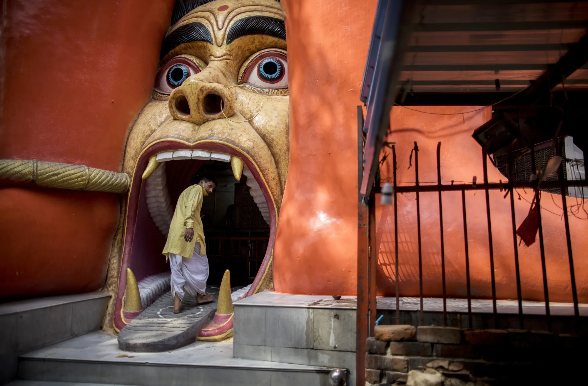 A priest enters the gate of a Hanuman Temple as lockdown restrictions are eased in New Delhi on June 16.